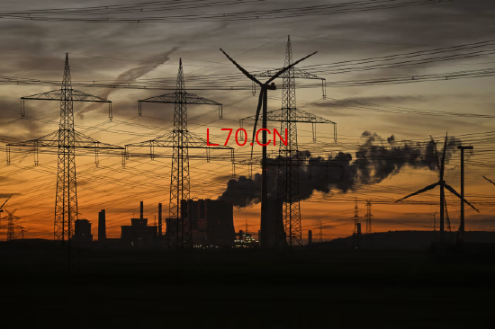 德国西部，莱茵集团运营电站冷却塔附近的风力发电机与输电线路。